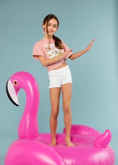 Girl Standing on Inflatable Flamingo – Free Stock Photo for Download