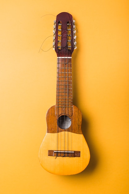 Ukulele with Broken String on Yellow Background – Free Download