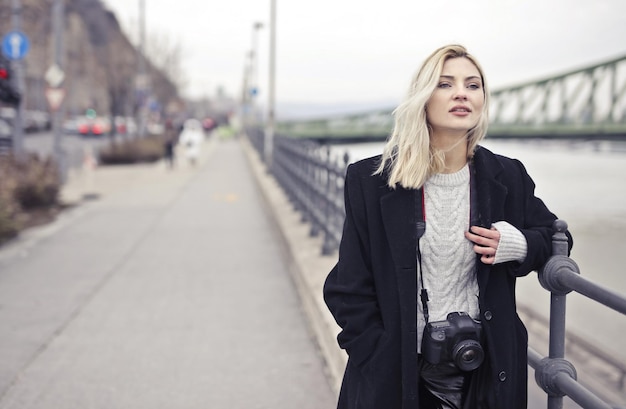 Portrait of Young Woman on a Bridge with a Digital Camera – Free to Download