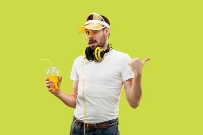 Young Man in Shirt with Headphones and Drink on Yellow Background – Free Download