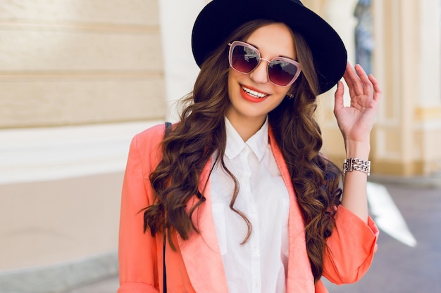 Outdoor High Fashion Portrait of a Stylish Woman in a Black Hat and Pink Suit – Free Download