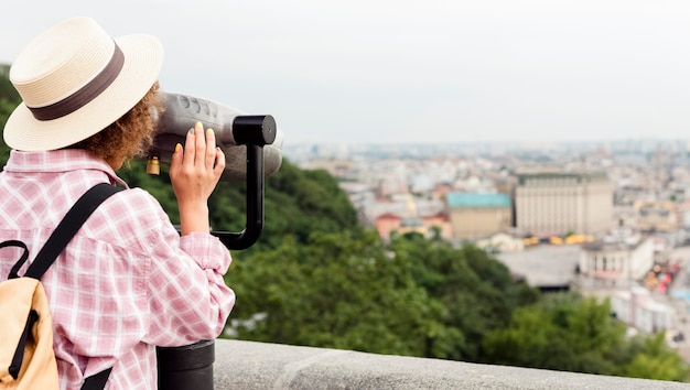 Curly Woman Gazing at the Town Through a Telescope – Free Download