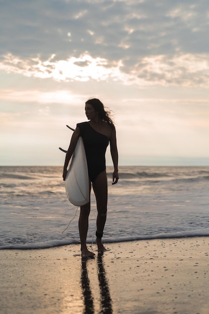 Woman Surfer with Surfboard on Ocean at Sunset – Free Download