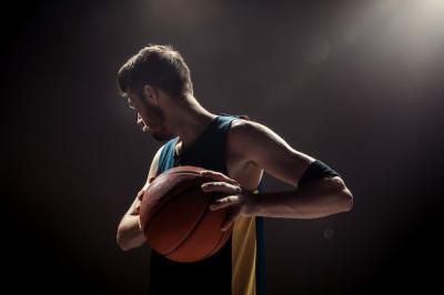 Silhouette of a Basketball Player on a Black Wall – Free Download