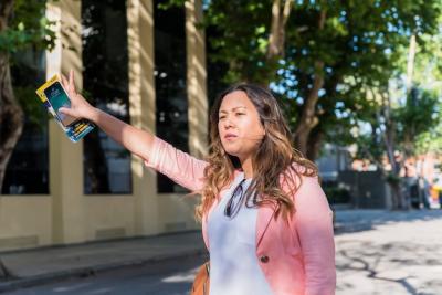 Female Tourist Hailing a Cab with Cellphone and Map – Free Download