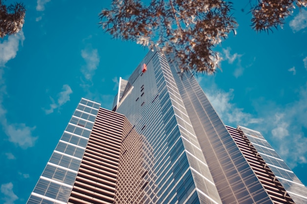 Low Angle Photograph of a Tall Business Building Against a Blue Cloudy Sky – Free Download