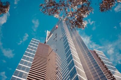 Low Angle Photograph of a Tall Business Building Against a Blue Cloudy Sky – Free Download