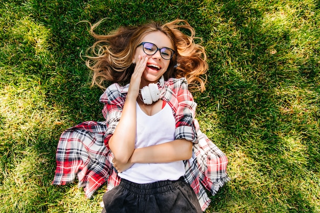 Cheerful Girl Lying on Grass and Laughing – Free Download