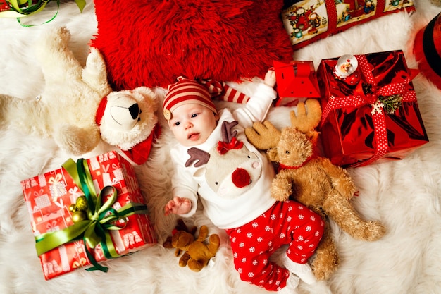 Little Baby in Red and White Clothes Surrounded by Christmas Presents and Toys – Free Stock Photo for Download