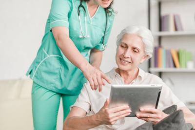 Nurse Assisting Senior Female Patient with Digital Tablet – Free Download