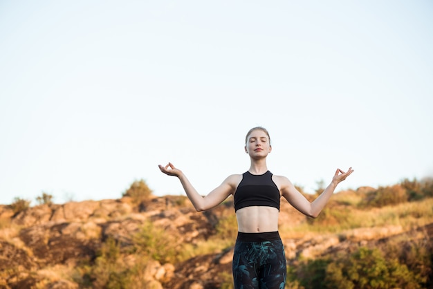 Young Sportive Woman Practicing Yoga Asanas in Canyon – Free Download