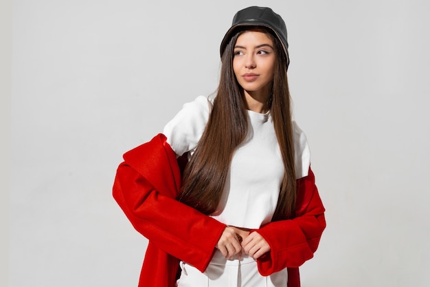 Pretty Girl in Black Hat and Red Coat Posing in Studio – Free Stock Photo for Download