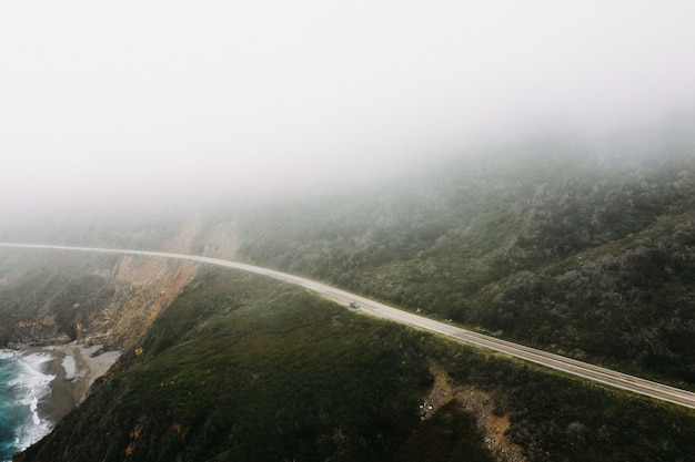 Distant Shot of a Highway Road Surrounded by Mountains and Trees – Free Download