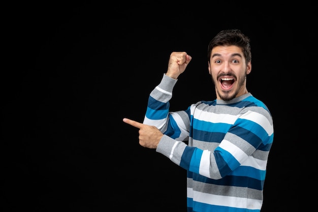 Young Male in Blue Striped Jersey Pointing at Copy Space – Free Download