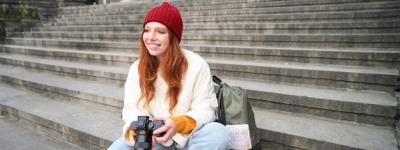 Young Student Photographer Reviewing Shots on Street Stairs – Free Download