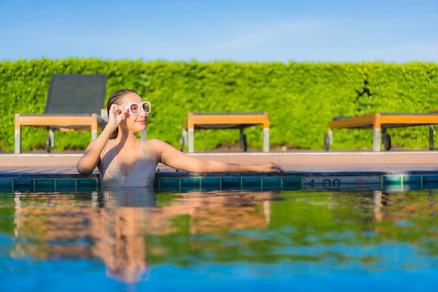 Beautiful Young Asian Woman Relaxing at Hotel Resort Pool – Free Download