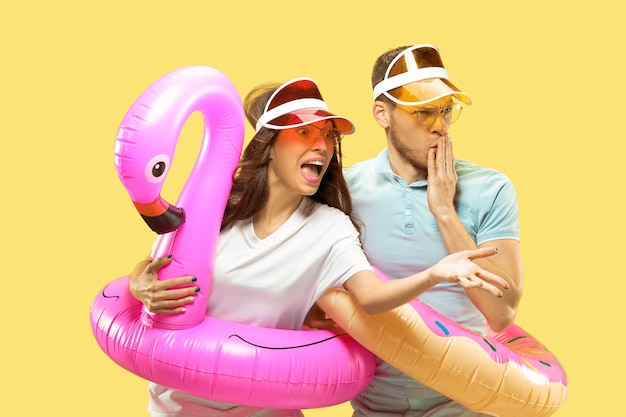 Young Couple in Caps and Sunglasses with Swimming Rings – Free Stock Photo for Summer Fun