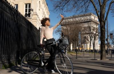 Woman Riding a Bike and Taking a Selfie in the City of France – Free Download