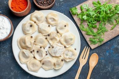 Delicious Baked Dumplings with Pepper and Greens on a Dark Background – Free Download