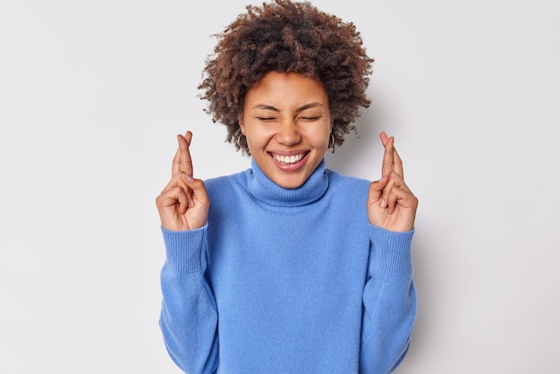 Happy Curly Haired Woman with Fingers Crossed for Good Luck – Free Download