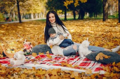 Family enjoying time with their little son in an autumn park – free stock photo for download