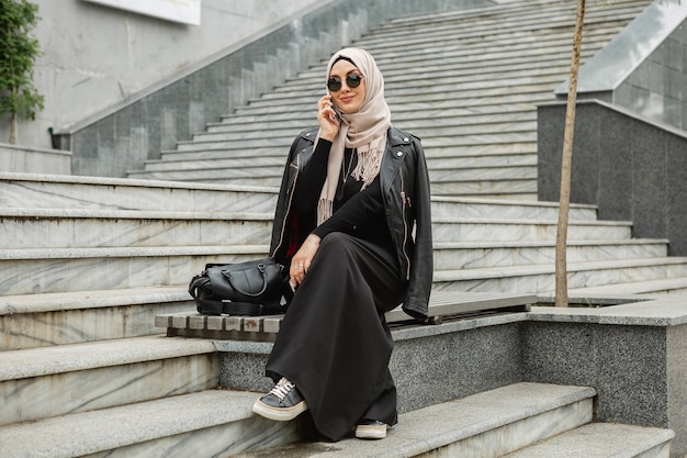 Modern Stylish Muslim Woman in Hijab and Leather Jacket Talking on Smartphone – Free Download