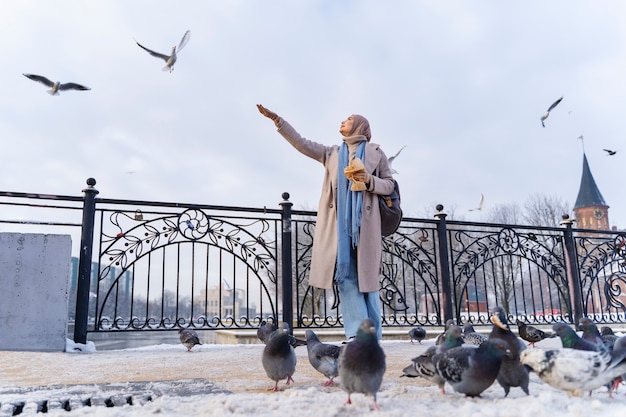 Muslim Woman Feeding Pigeons in the City – Free Stock Photo for Download