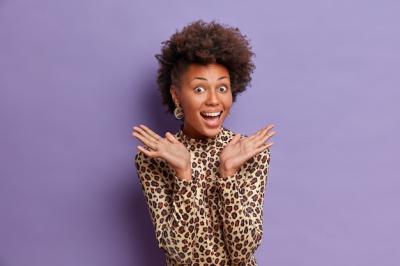 Joyful Dark-Skinned Woman with Curly Natural Hair Celebrating Excellent News – Free Download