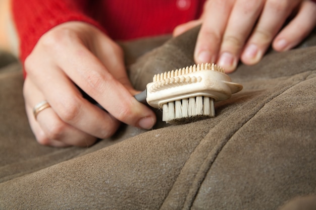 Woman Cleaning a Sheepskin with a Whisk Broom – Free Stock Photo for Download