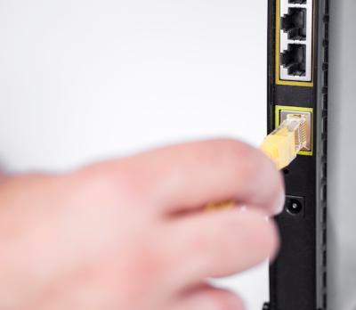 Hand Plugging Ethernet Cable into Router – Free Download