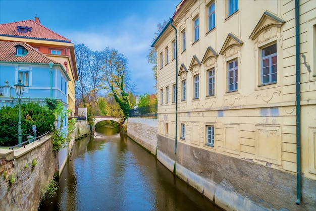 Canal Flowing Between Buildings Near the Lennon Wall in Mala Strana, Prague – Free Download