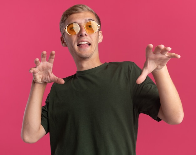 Joyful Young Handsome Guy in Green Shirt and Glasses Making Tiger Style Gesture – Free Stock Photo for Download