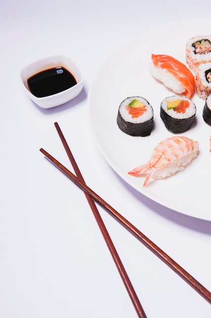 Chopsticks and Sauce Next to Sushi – Free Download