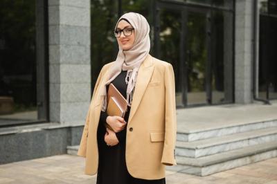 Modern Stylish Muslim Woman in Hijab and Business Jacket Walking in City Street with Laptop – Free Download