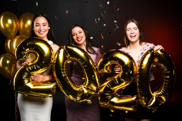 Women Celebrating New Year’s with Golden Balloons â Free Download