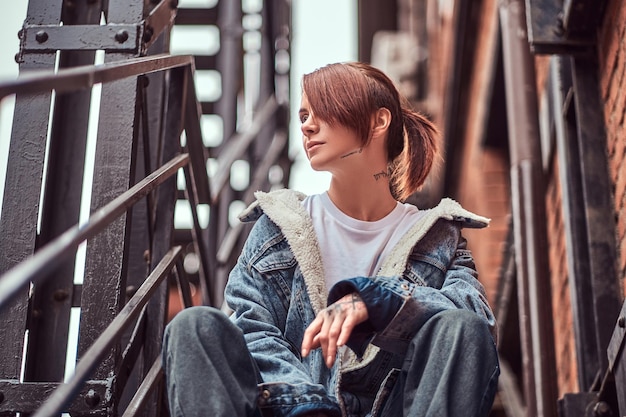 Trendy Tattooed Redhead Girl Sitting on Stairs – Free Download