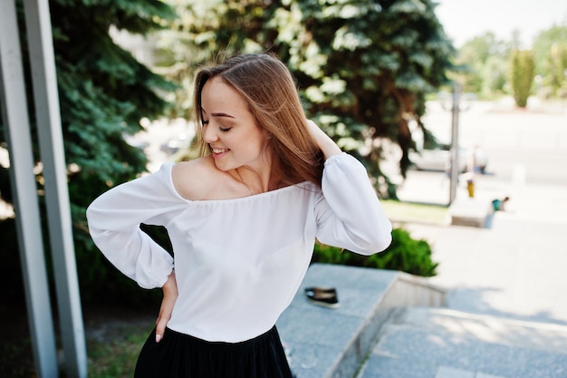 Stunning Portrait of a Woman in White Blouse and Black Pants Amidst Pine Trees – Free Download