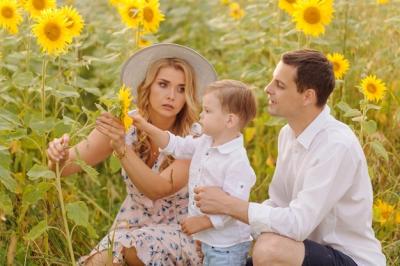 Happy Young Family Embracing in a Sunflower Field – Free to Download