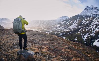 Stunning Male Hiker Capturing Snow-Covered Rocky Mountains – Free Download