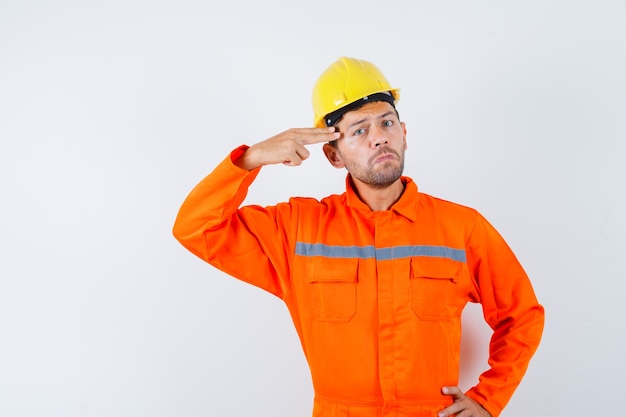 Young Worker in Uniform Pointing Hand to Head – Free Stock Photo, Download Free