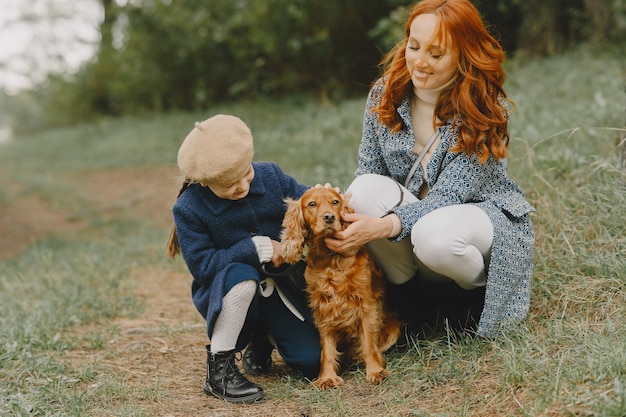 Mother and Daughter Enjoying Time with Their Dog in an Autumn Park – Free Download