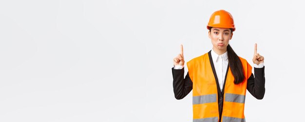 Displeased Asian Female Architect in Safety Gear | Free Stock Photo for Download