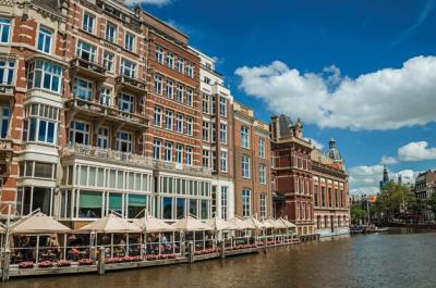 Canal with Typical Brick Building and Restaurant in Amsterdam, Netherlands – Free Download