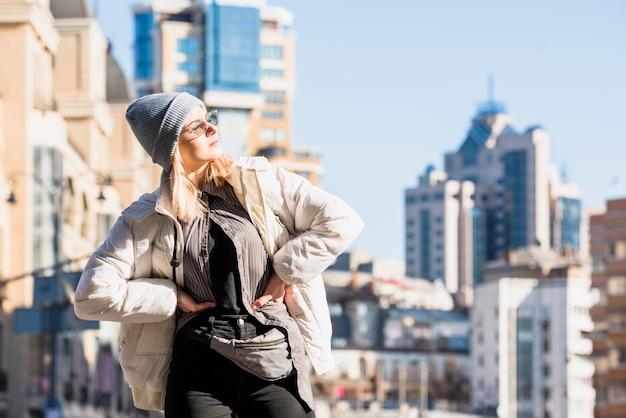 Blonde Young Woman Posing with Hands on Hips Against City Skyline – Free Stock Photo