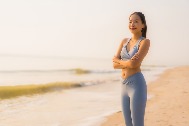 Portrait of a Young Asian Woman Preparing to Run on the Beach – Free Download