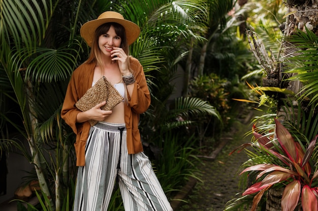 Elegant Girl in White Top and Straw Hat Surrounded by Palm Leaves in Bali – Free Download