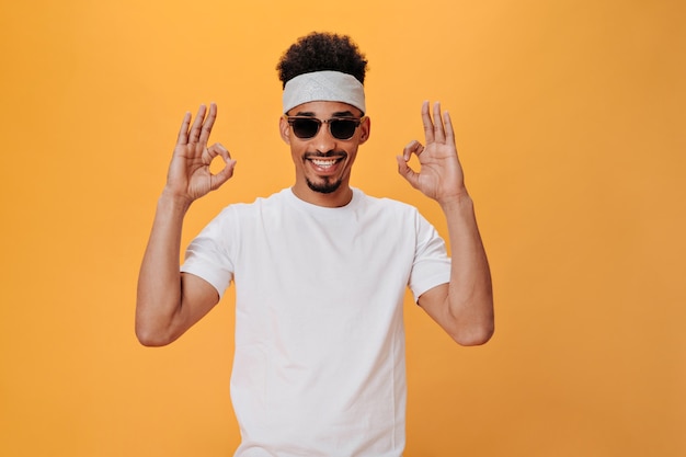 Young Man in Headband and Stylish Glasses Making an OK Sign – Download Free Stock Photo