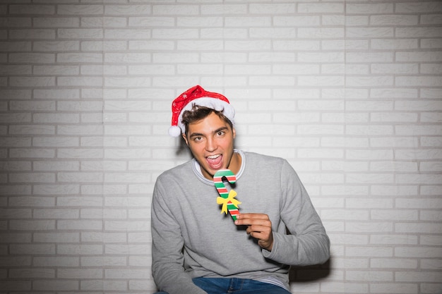 Man Holding a Fake Candy Cane – Free Stock Photo for Download