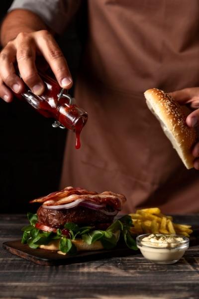 Man Adding Sauce to Burger – Free Stock Photo | Download for Free