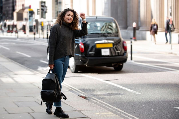 Young Woman Hailing a Taxi in the City – Free Download